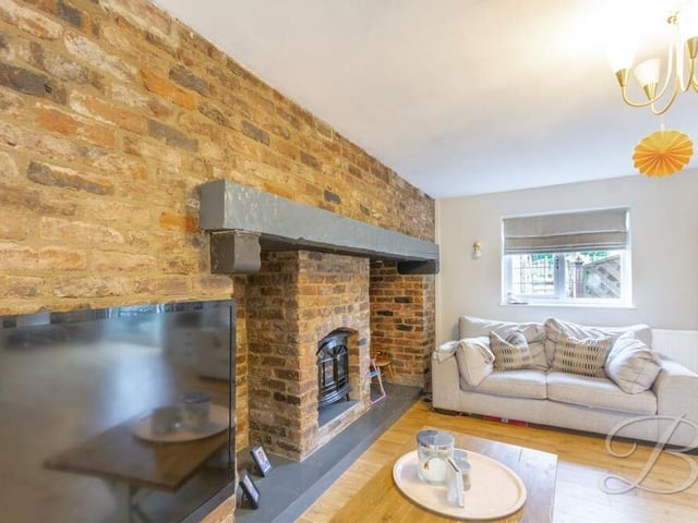 A feature fireplace with open-brick surround is one of the highlights of the living room.