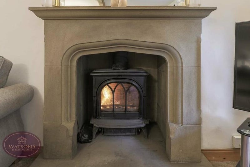 Here is a close-up of the sandstone fireplace, with inset multi-fuel burner, in the lounge at the Bagthorpe property.