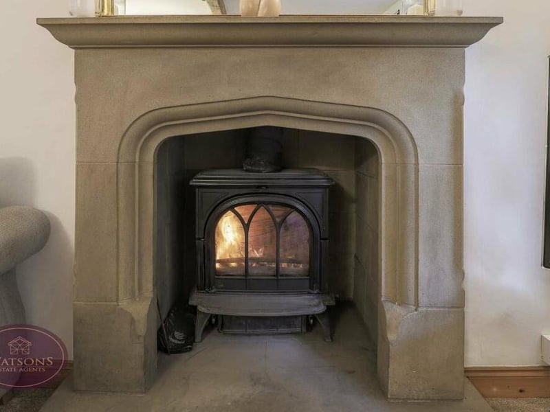 Here is a close-up of the sandstone fireplace, with inset multi-fuel burner, in the lounge at the Bagthorpe property.
