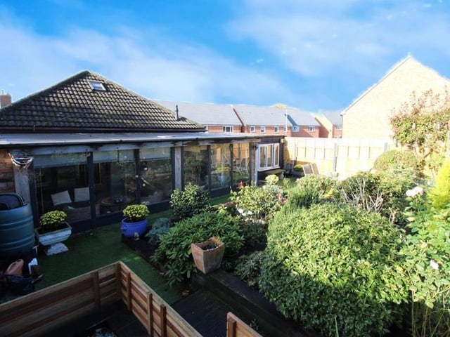 An aerial shot that shows how attractive the rear garden is, with its plants and shrubs, and space for relaxing in the summer sun.