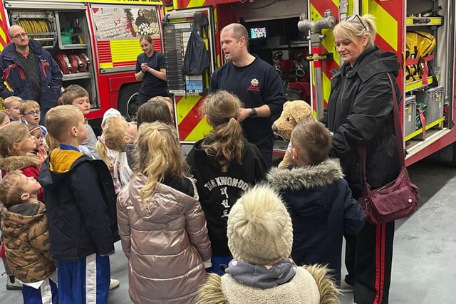 Children listen to a firefighter.