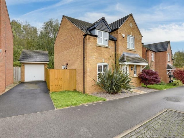 We round off our gallery with a handful of exterior photos. This one shows the front driveway that provides off-street parking space and leads to a detached garage, which has an up-and-over door, lighting and electricity. The front garden comprises lawned and gravelled areas.