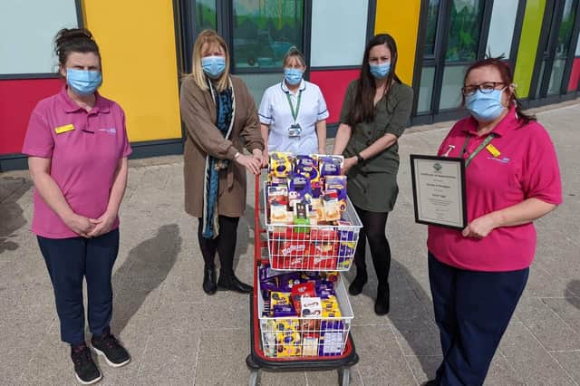 Salon owner Hayley Wood (second left) and manager Alanya Jennings (second right) presenting a trolley full of Easter eggs to staff at King's Mill Hospital.