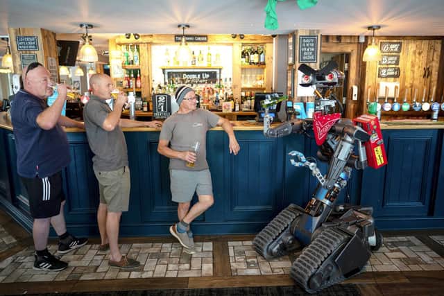 Johnny 5 joins workmen for a pint in the pub. Photo: Tom Maddick/SWNS