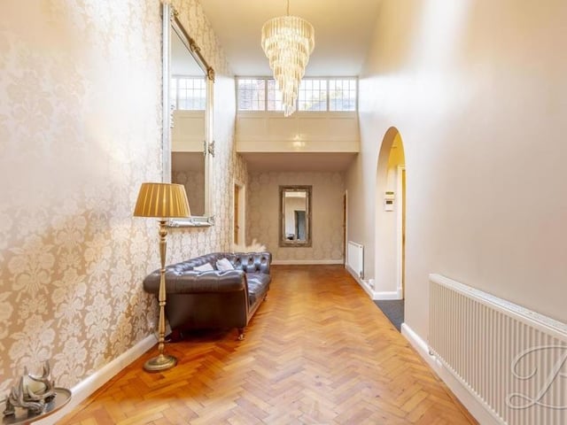 Another shot of the grand hallway as it extends into the heart of the house. It boasts classic parquet flooring, neutral decor and a wealth of natural light.