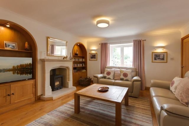 The focal point of the sitting room is a feature wall, which incorporates a Stovax log-burning stove, with a stone mantle, surround and hearth. There are also two inset oak storage units with recessed light points, open shelving and cupboards.