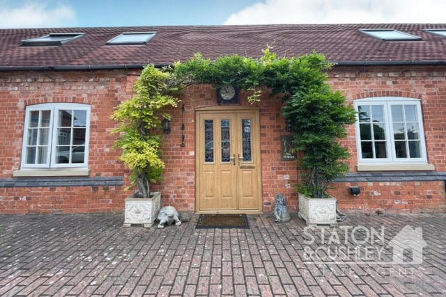 The charming entrance to the property, complete with distinctive front door and overhead clock.