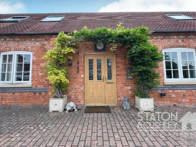 The charming entrance to the property, complete with distinctive front door and overhead clock.