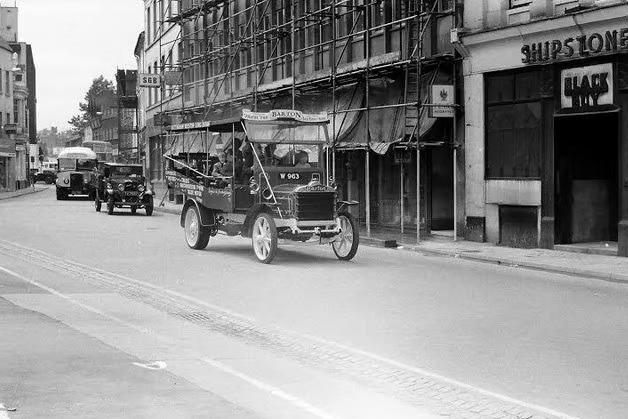 Old buses are being paraded through the market place in 1970.