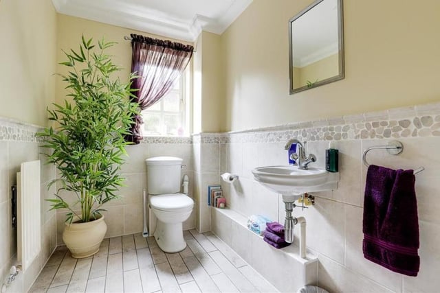 Even the downstairs toilet is beautifully presented. It comprises a low-flush WC, a wall-mounted hand wash basin, tiled flooring and partly tiled walls. (By the way, we also love the plant!)