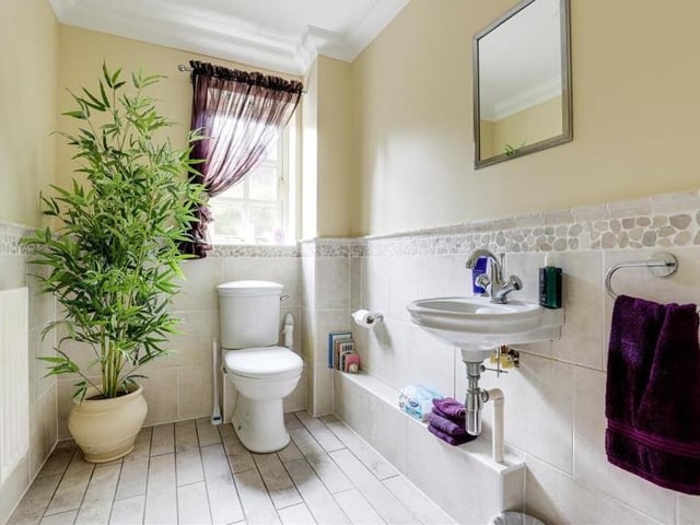 Even the downstairs toilet is beautifully presented. It comprises a low-flush WC, a wall-mounted hand wash basin, tiled flooring and partly tiled walls. (By the way, we also love the plant!)