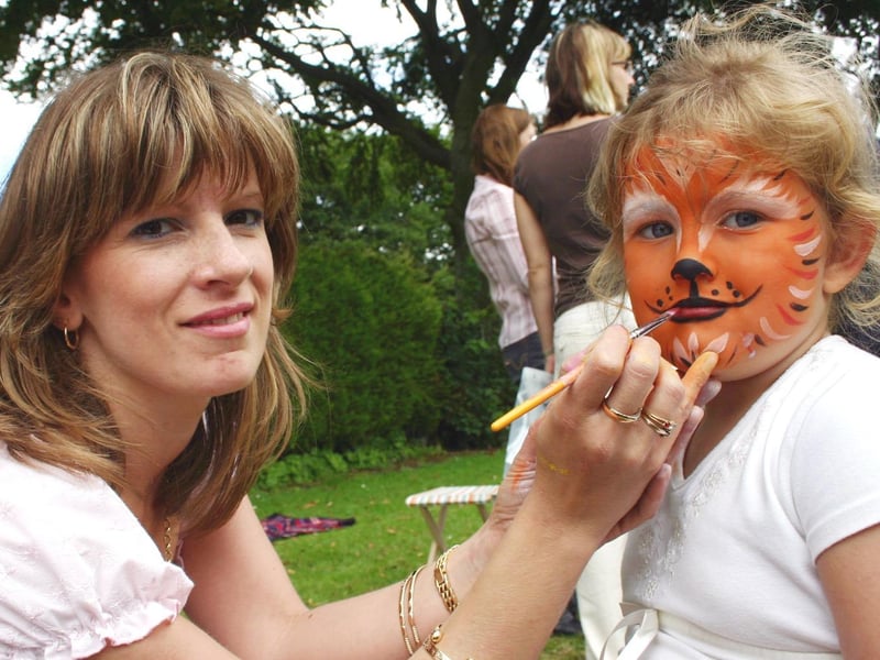 Charlotte Ashworth, aged five, has her face painted as a tiger by Lisa Slaney at the Orchards Primary School summer fair. It was the first summer fair at the school in Kirkby and funds raised will buy adventure play equipment for pupils.
