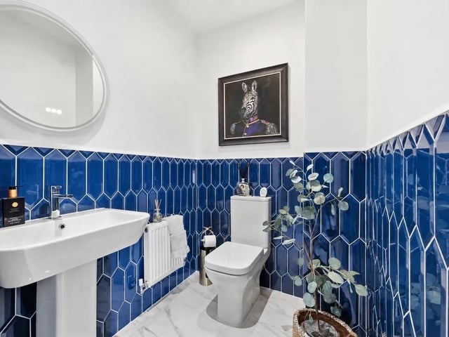 The ground floor cloakroom has been stylishly upgraded with striking feature tiling