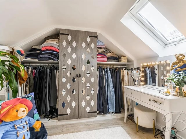 Dressing room with built in wardrobes, wooden flooring, spot lighting and velux window.