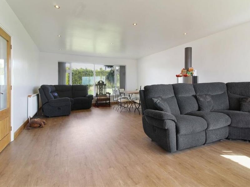 The lounge from a different angle, with large windows at the front end of the property letting in lots of natural light.