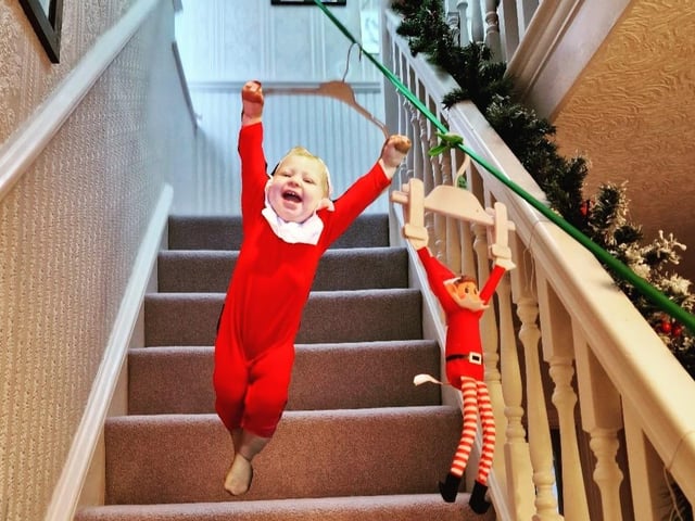 Bubbles the Elf and the traditional Elf on the Shelf ziplining down the stairs