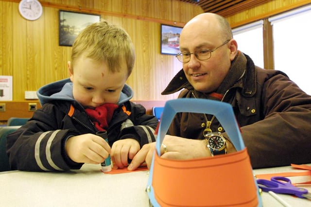 Matthew Dallow three, of Harpenden glues the final piece of his mini tram with father Ian at the children's workshop at Crich Tramway Museum in 2006