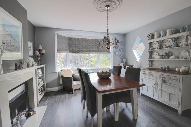 Through the front door and into the entrance hallway, the first room you come to is this dining area, which forms part of an open-plan kitchen. It boasts a feature fireplace and a bay window