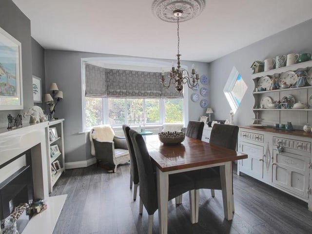 Through the front door and into the entrance hallway, the first room you come to is this dining area, which forms part of an open-plan kitchen. It boasts a feature fireplace and a bay window