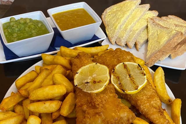 The meal includes two pieces of IPA battered cod, four slices of bread and butter, mushy peas, curry sauce, tartar sauce and chunky chips.