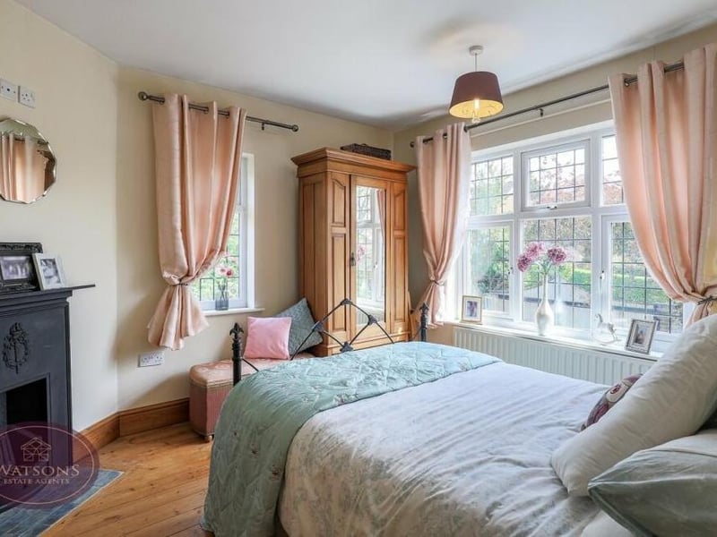 The elegant character of the house is summed up in this bedroom, which has exposed wooden flooring and a feature fireplace.