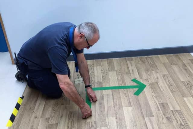 Shirebrook Academy site staff manager Paul Plastow fixes arrows to the floor in order to establish a one-way system.