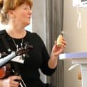 Opus musician Sarah Matthews and a patient make music.