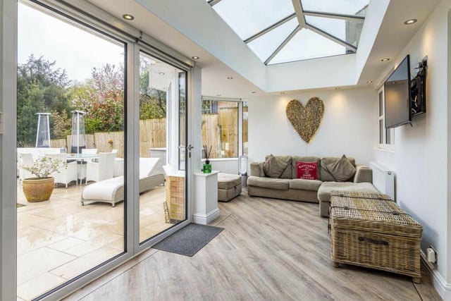 Attached to the kitchen is this modern orangery, which is bathed in natural light and overlooks the verdant garden and woodland beyond,