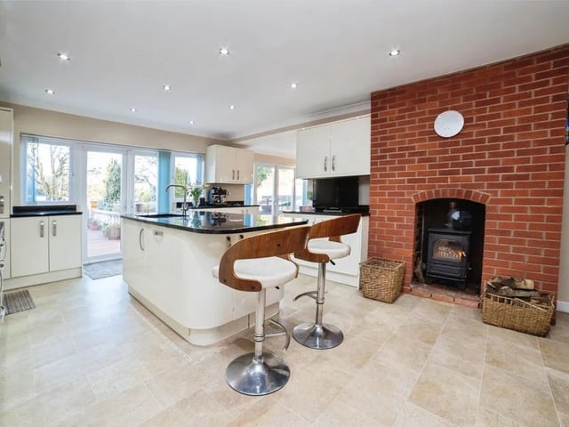 A multi-fuel burner sits within this open plan kitchen/living space, adding warmth and character while creating a cosy focal point.