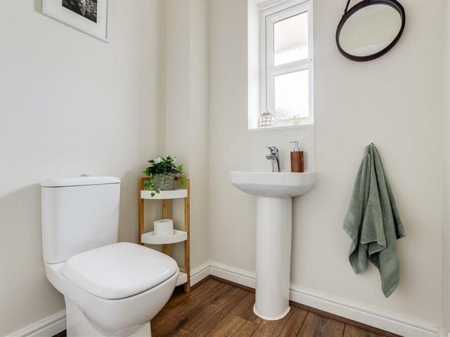 A downstairs toilet is always useful -- and this one is no exception. It comprises a low-level, dual-flush WC, pedestal wash basin and wood-effect flooring.