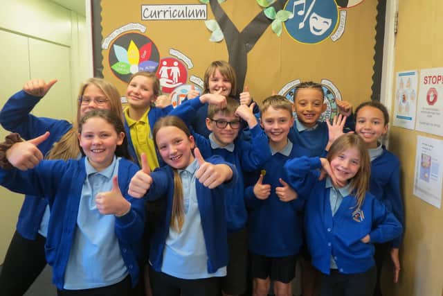 Children at Awsworth Primary School celebrate the school's recent 'good' Ofsted report.