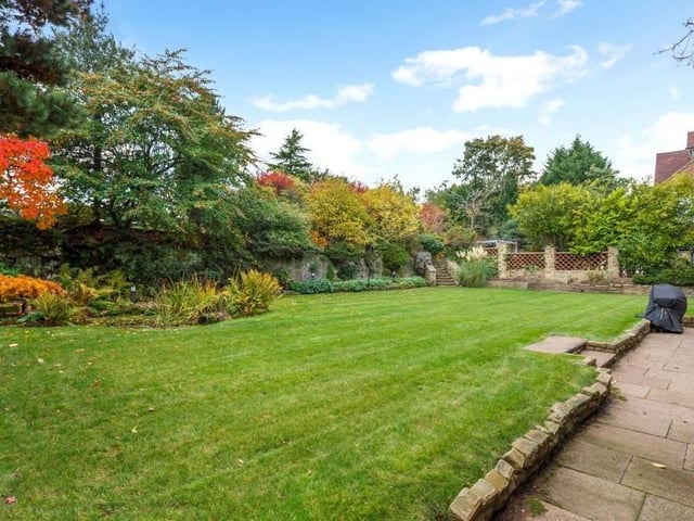 Let's take a quick look outside before we leave the £1.25 million Mansfield stunner. The rear garden is mainly laid to lawn, with with a pond, lighting and established tree-lined borders. Stone steps lead to an elevated patio area.