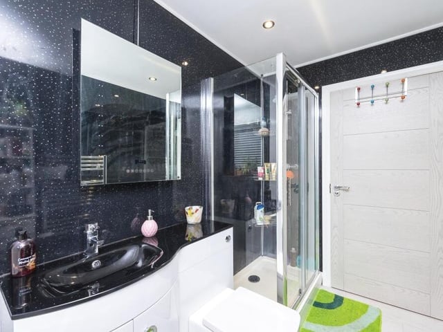 The eyecatching family bathroom sits on the ground floor of the dormer-style bungalow. A four-piece suite is made up of a panelled bath, double shower enclosure, wash basin and WC.