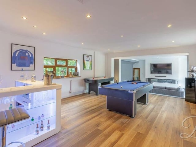 One of the highlights of the Huthwaite property is this spacious games room, with a contemporary, fitted bar that has shelving. As you can see, there is space for a pool table or snooker table. A laminated floor, downlights and windows to the front and back of the bungalow add to its appeal. The room also gives open access to the sitting room.