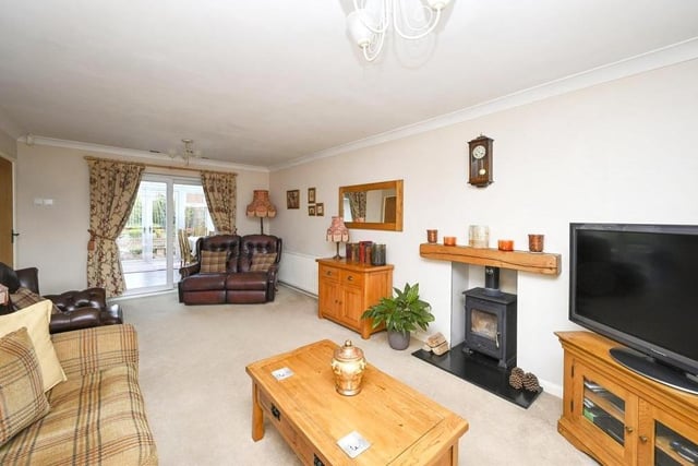 The main reception room is this spacious, dual-aspect lounge, which features a free-standing, multi-fuel burner, inset into the chimney. Double-glazed, sliding doors at the back open into the conservatory.