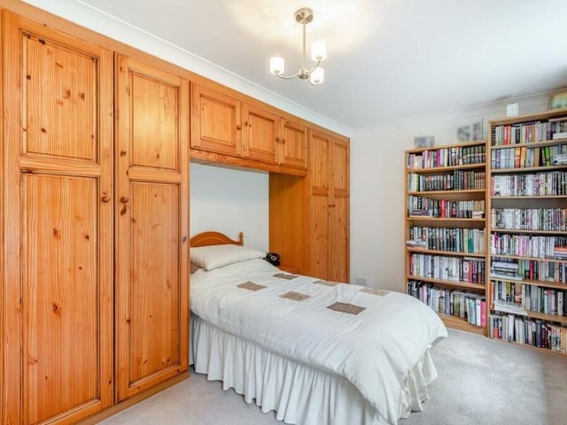 This is the third bedroom on the first floor. Among its assets are fitted wardrobes with hanging rails and shelves, and additional overhead storage cupboards.