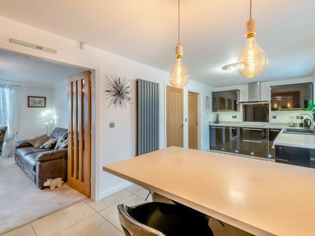 This photo shows how the kitchen/breakfast room flows seamlessly into the lounge via double doors. Note also the contemporary vertical radiator.