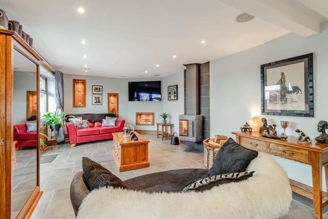 The open-plan sitting room boasts in-ceiling surround-sound speakers, ceiling spotlights, a tiled floor and two floor-to-ceiling vertical radiators, as well as underfloor heating.