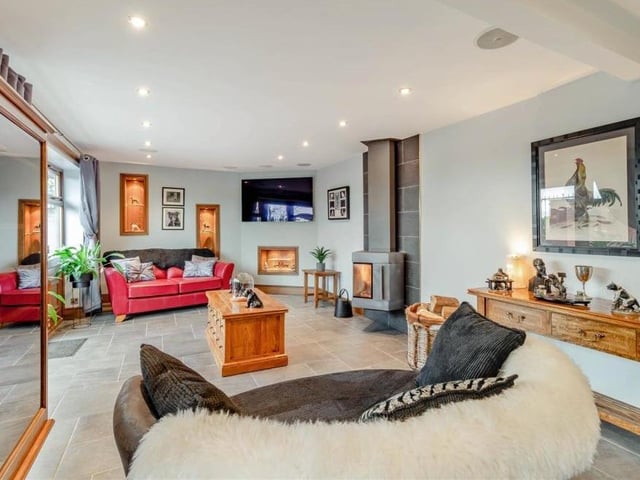 The open-plan sitting room boasts in-ceiling surround-sound speakers, ceiling spotlights, a tiled floor and two floor-to-ceiling vertical radiators, as well as underfloor heating.