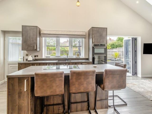 At the heart of the kitchen is a large central is;land, with matching base units and drawers, including pan drawers, matching work surfaces and an integrated AEG induction hob.