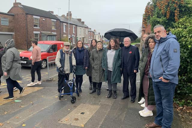 Coun Andy Cooper with the school head and parent campaigners next to the busy road they want a crossing on. Photo: Submitted