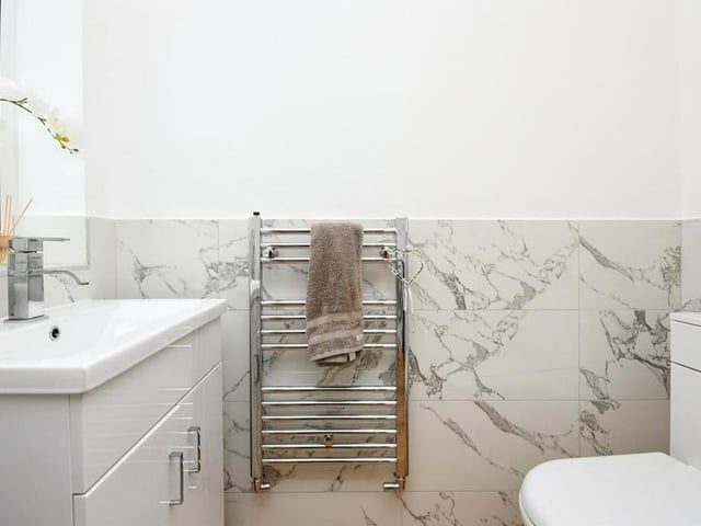 Before we move upstairs, let's have a quick one in the ground-floor toilet, which is fitted with a WC, wash hand basin with vanity unit and mixer tap, and a towel radiator.