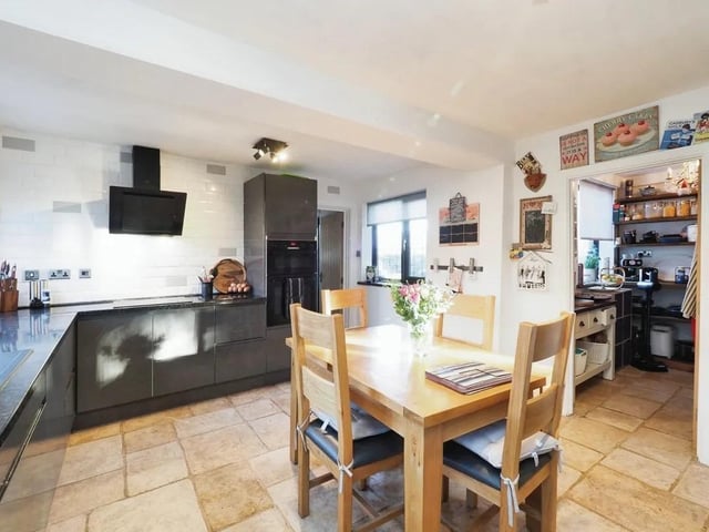 The breakfast kitchen has a range of base units with character shelving, work surfaces, a double sink, a built-in double oven with an induction hob, space for an American style fridge freezer, and tiled flooring with underfloor heating.