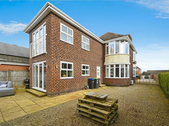 The property has a spacious gated driveway and patio area.