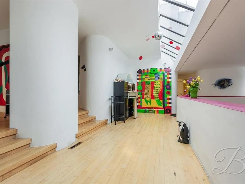 The home boasts unique architectural details, such as curved walls and varying levels, which create an open, dynamic living space.