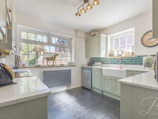 On the opposite side of the hallway to the living room is this brilliant kitchen, fitted with shaker cabinets and units, which are complemented well by tiling and a Belfast sink.