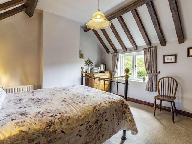 Let's take a look upstairs now, beginning with this beautiful master bedroom. Its cute window and ceiling beams add personality.