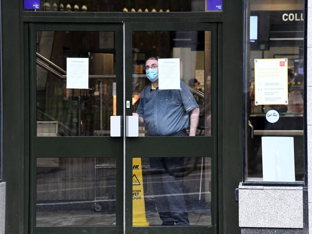 A McDonalds employee is seen as the restaurant is only open for take away on August 5, 2020 in Aberdeen, Scotland. (Photo by Jeff J Mitchell/Getty Images)
