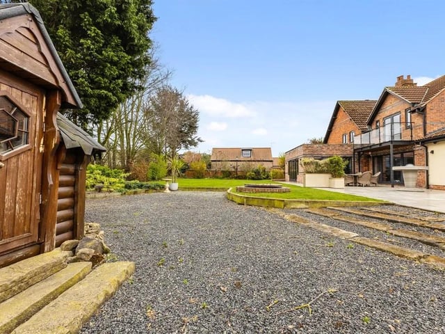 There is a fabulous Indian flagstone patio and terrace, with barbecue and cooking facility, plus further private seating area. A Swiss cottage style summer house completes the outside.