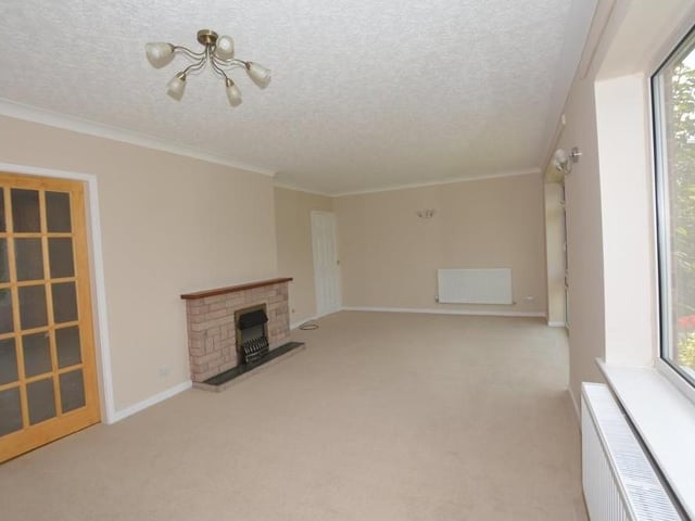 A second shot of the attractive, good-sized living room or dining room. It boasts a feature fireplace with inset coal-effect electric fire, slate hearth, stone surround and timber mantelpiece.